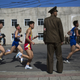 Marathon runners pass by a North Korean soldier.
